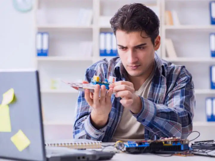 Man checking a computer part in the comfort of his house in Miami, Florida. He wonders whether he should send his computer to repair by a professional technician, or not.