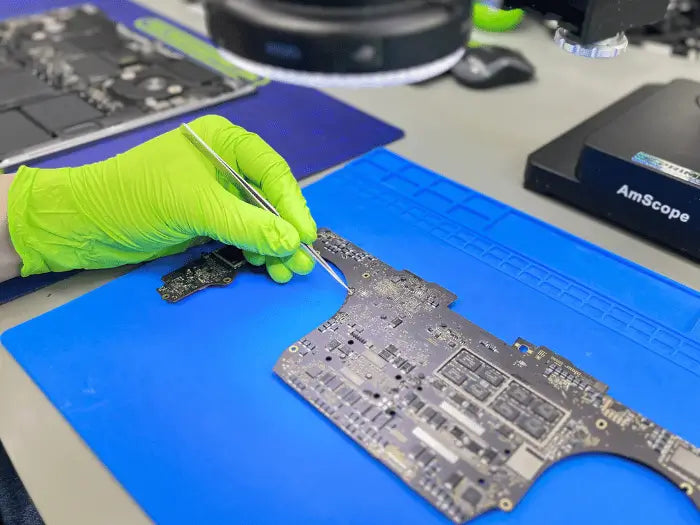 Prime Tech Support technician repairing a Macbook Pro due to liquid damage.