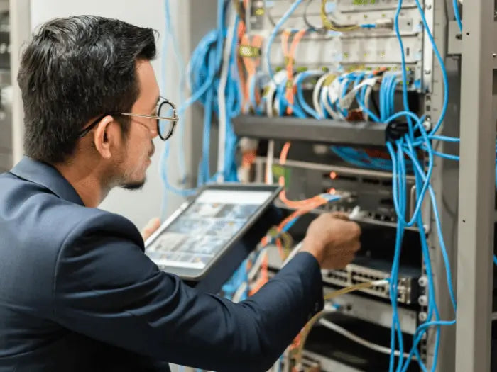 Technician performing diagnostics and repairs on a wired network infrastructure, ensuring optimal functionality.