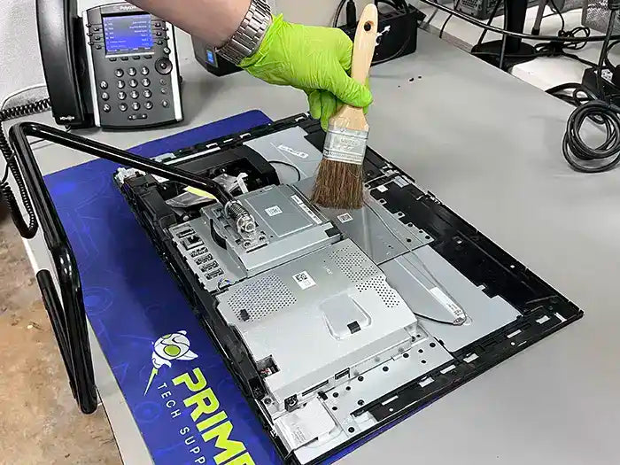  In our Miami-based Prime Tech Support Lab, a technician provides an All-in-One computer cleaning service. They use a brush to remove dust and prevent overheating, ensuring optimal performance of the unit.