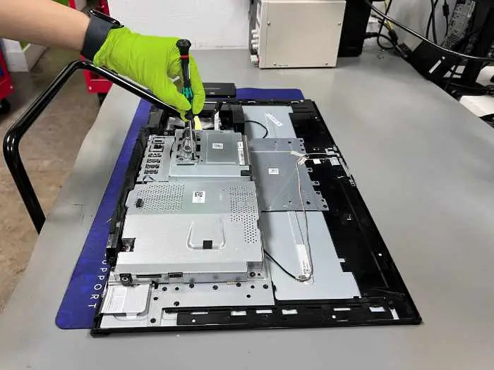 Prime Tech Support technician using a screwdriver to perform a power supply service for an All-in-One customer in Prime Tech Support Lab in Miami