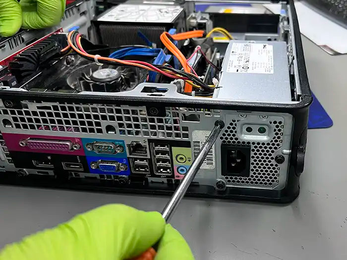 Technician in Miami using a screw driver to dissemble the desktop computer and perform a diagnostic to find the possible cause of the problem.