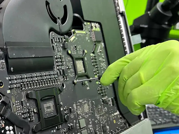 At our Miami lab, a technician uses a screwdriver to carefully disassemble the iMac after diagnosing the reported video issue from the customer.
