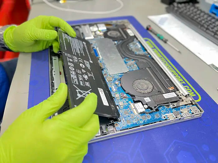 In our lab located in Miami-Dade County, a Prime Tech Support technician holds a laptop battery, ready to replace it for a customer's device.