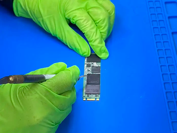 In Miami, a technician provides data recovery service for a client. Using a microscope, the technician carefully examines and repairs memory damage in the laptop to recover the data.