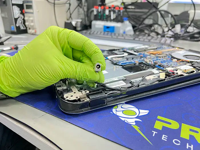 In our Miami-based specialized lab, a technician is carrying out a DC jack repair service for a client. They carefully examine the laptop's DC jack port to pinpoint and resolve any issues.