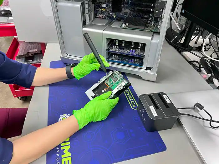Prime Tech Support technician using a screwdriver to dissemble a Mac Pro hard drive to perform a Data Recovery Service for a client located in Miami