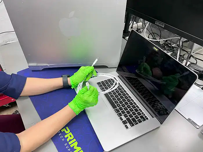 Prime Tech Support technician using a usb cable to perform a data transfer service for a Mac Pro user located in Miami