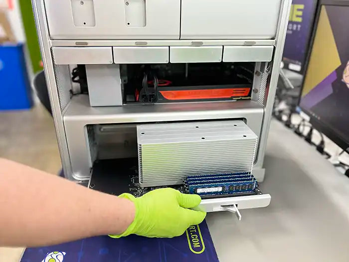 Prime Tech Support technician wearing green gloved while accessing to the memory part of a customer's Mac Pro computer to upgrade it in our Lab located in Miami