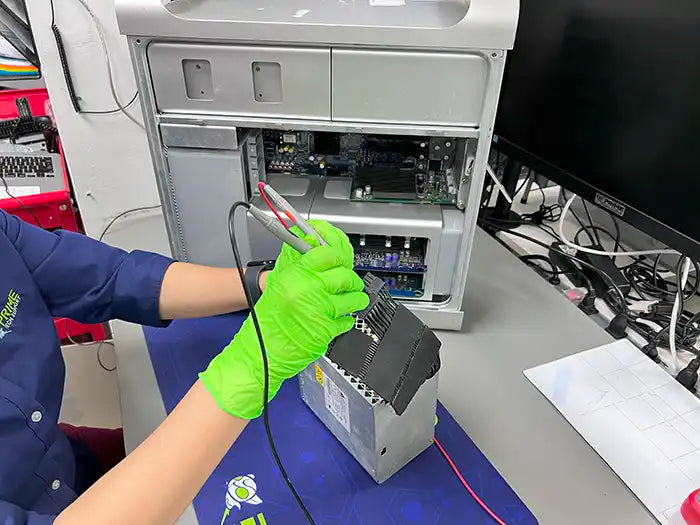 Prime Tech Support Technician using a voltage tested to repair a Mac Pro power supply issue for a customer located in Miami