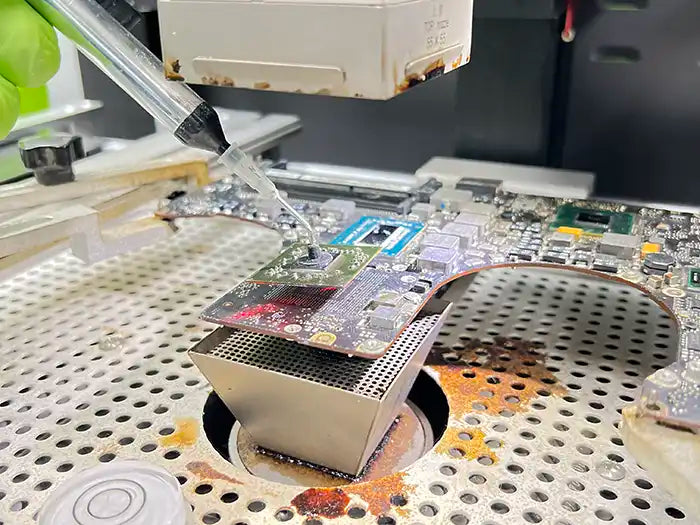 At Prime Tech Support's modern lab in Miami, FL, a technician is providing video repair services for a MacBook Pro. Using a microscope, the technician carefully examines the unit for any potential damage and utilizes micro soldering techniques for repairs if needed.