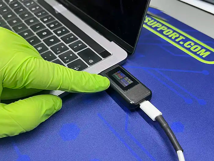 Prime Tech Support technician using a voltage tester to diagnose the DC Jack port of a MacBook Pro for a client in Miami