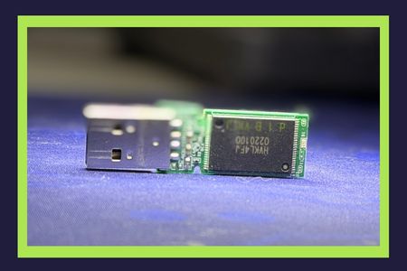 Disassembled USB flash drive prepared for data recovery evaluation, with exposed circuit board ready for microscope repair of damaged connections