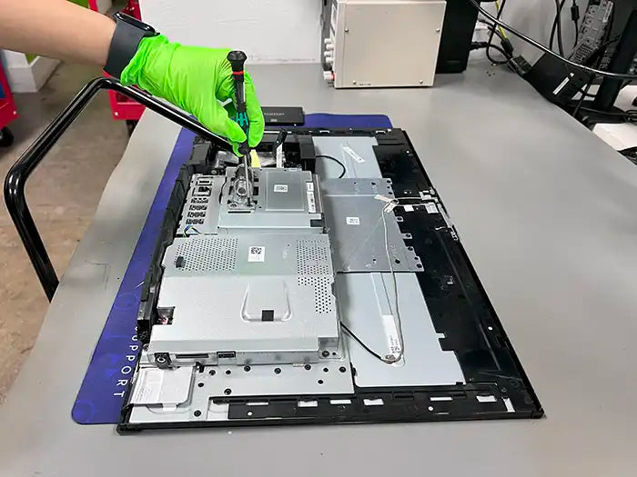 Prime Tech Support technician using a screwdriver to perform a hardware upgrade for an All-in-One customer in Prime Tech Support Lab in Miami 