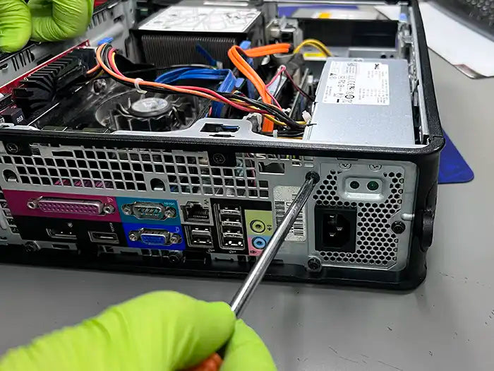 Technician in Miami using a screw driver to dissemble the desktop computer and perform a diagnostic to find the possible cause of the problem. 