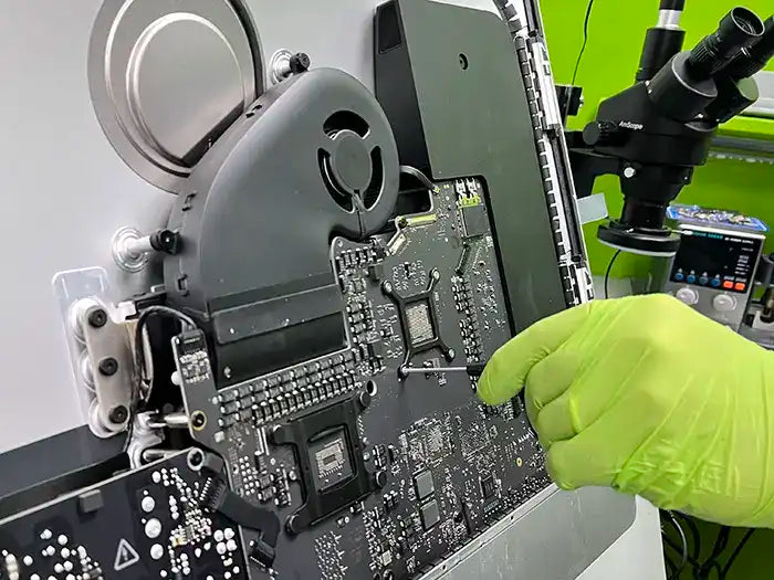 iMac hardware upgrade service performed in Prime Tech Support lab in Miami. The technician is using a screwdriver to carry out the hardware upgrade