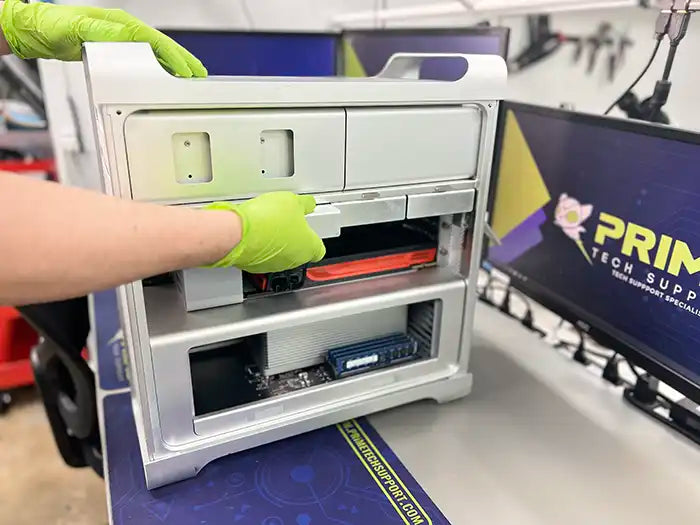  At Prime Tech Support's specialized lab in Miami, a technician wearing green gloves expertly carries out a hard drive replacement for a Mac Pro.