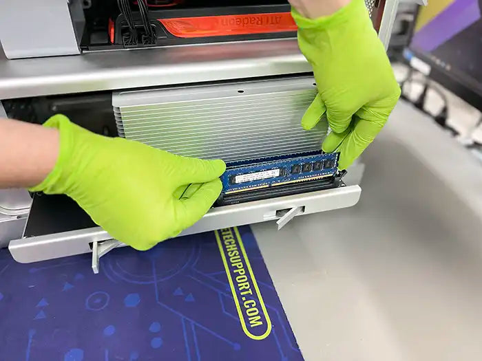 In our Miami-based lab, a Prime Tech Support technician, wearing green gloves, accesses the memory section of a customer's Mac Pro computer to perform an upgrade.