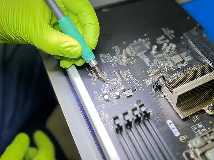In Prime Tech Support's specialized lab located in Miami, a technician carefully inspects and repairs the Mac Pro logic board using a microscope. The technician thoroughly tests and examines the logic board to identify any issues and proceeds with the necessary repairs.