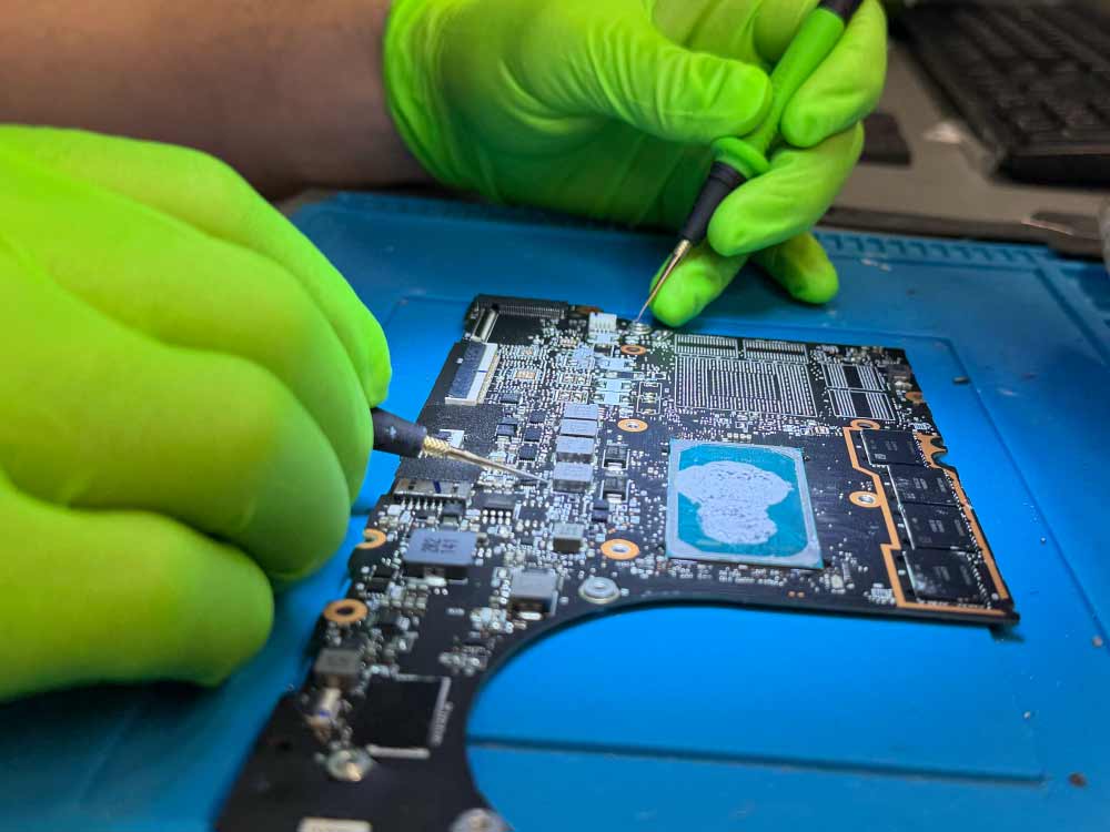 MacBook Pro data recovery performed in a professional Miami lab, showing board-level diagnostics and microsoldering on a MacBook logic board.
