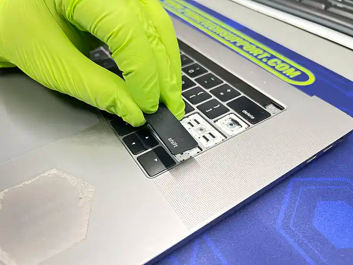 MacBook keyboard replacement being performed in Prime Tech Support specialized lab located in Miami. Technician is replacing shift tab and other tabs to repair them
