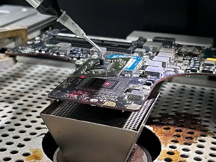 In Prime Tech Support's modern lab located in Miami, FL, a technician performs video repair services for a MacBook Pro. With the help of a microscope, the technician carefully inspects the device for possible damage and uses micro soldering techniques to fix any issues if necessary.